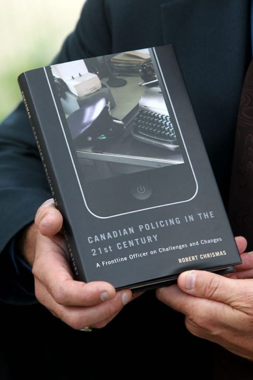 Police Sgt Bob Chrismas with his new published book on Canadian Policing in the 21st Century.  Christmas holds his book while outside the Public Safety Building in Winnipeg. Sept  11,, 2013 Ruth Bonneville Winnipeg Free Press