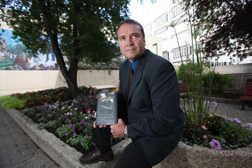 Police Sgt Bob Chrismas with his new published book on Canadian Policing in the 21st Century.  Christmas holds his book while outside the Public Safety Building in Winnipeg. Sept  11,, 2013 Ruth Bonneville Winnipeg Free Press