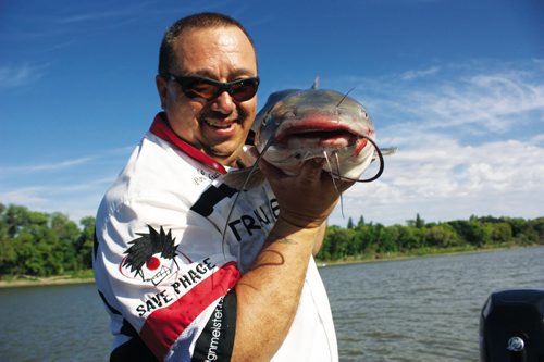 Canstar Community News Aug. 31, 2013 - WindRiver Professional Guide Services founder Frank Normand is shown with a catfish caught on the Red River near Selkirk on Aug. 31. (DAN FALLOON/CANSTAR COMMUNITY NEWS/HERALD)