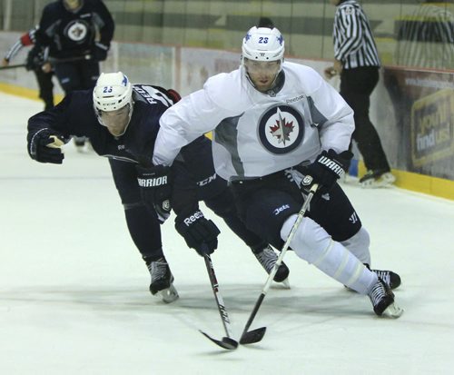 At left, Defenceman #25 Zach Redmond against #26 right winger Blake Wheeler in scrimmage on the first day of Winnipeg Jets training camp held at the MTS Iceplex Thursday morning.  Ed Tait story Wayne Glowacki / Winnipeg Free Press Sept. 12 2013