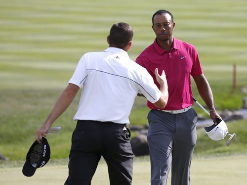 Sergio Garcia, left, and Tiger Woods shake hands after the third round of the BMW Championship golf tournament at Conway Farms Golf Club in Lake Forest, Ill., Saturday, Sept. 14, 2013. (AP Photo/Charles Rex Arbogast)
