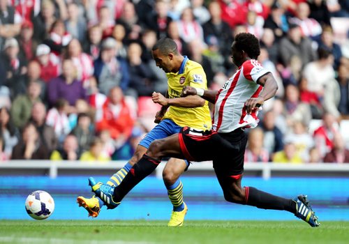 Arsenal's Theo Walcott, left, vies for the ball with Sunderland's Modibo Diakite, right, during their English Premier League soccer match at the Stadium of Light, Sunderland, England, Saturday, Sept. 14, 2013. (AP Photo/Scott Heppell)