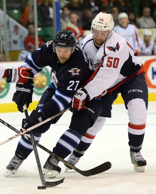Washington Capitals' Dane Byers fights to get the puck from Winnipeg Jets' Eric Tangradi during pre-season NHL hockey action in Belleville, Ontario on Saturday, Sept. 14, 2013. THE CANADIAN PRESS/Sean Kilpatrick