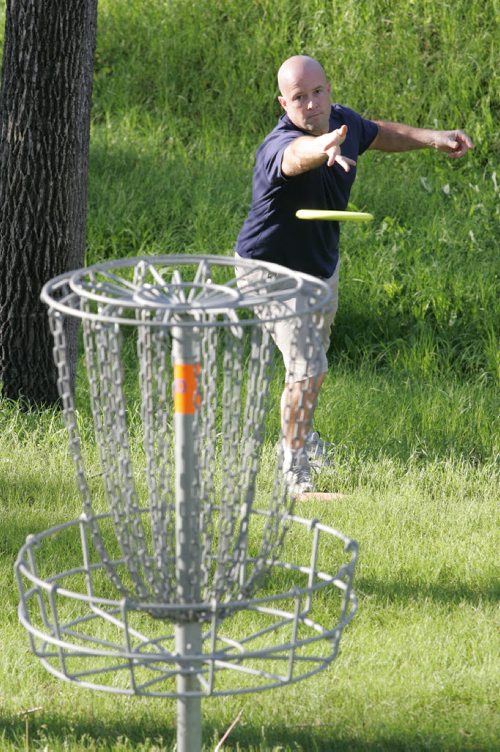 BORIS MINKEVICH / WINNIPEG FREE PRESS  060605 Disc golfer Casey Dixon throws the disc at the golf basket (hole). Photo taken at Happyland Park Disc Golf Course in St. Boniface.BORIS