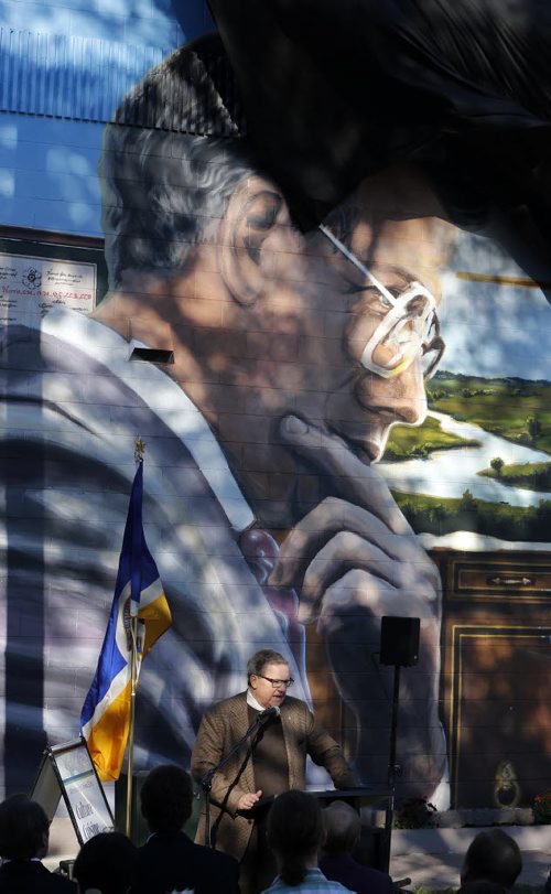 Stdup in pic Dr. Lloyd Axworthy specak about  former Mayor  Bill Norrie as the wind blows the  curtain away from the giant mural about to be unvieled  featuring Willam Norrie and his wife  Helen -Mural of the late William ( Bill ) Norrie , (1979-92) former mayor of Winnipeg , Rhodes Scholar ,  his wife Helen Norrie ( she also appears in the mural) unveils the  mural by artist Michel Saint Hilaire  & Mandy van Leeuwen , the mural is located  at the corner of Ellice Ave. At Langside St. and is the 70th mural  sponsored by the West End Biz KEN GIGLIOTTI / SEPT 17 2013 / WINNIPEG FREE PRESS