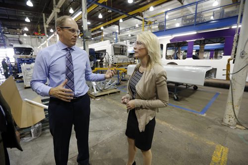New Flyer bus assembly line in background - (right) Candice  Bergen Minister of State and Social Development  toured the  New Flyer bus plant in Transcona  with (left)  New Flyer's  David White Executive  Vp of Suply Management  as part of a cross country tour supporting  Canadian manufacturers , in pic  KEN GIGLIOTTI / SEPT 18 2013 / WINNIPEG FREE PRESS