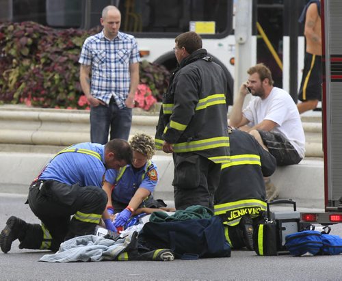 Winnipeg Fire Paramedics attend to an injured male cyclist after he collided with a vehicle on the turn off on the Disraeli Fwy. near Main St. Wednesday afternoon.   Wayne Glowacki / Winnipeg Free Press Sept. 18 2013