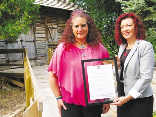 Canstar Community News Sept. 11, 2013 - Sandra Horyski (left) and MLA Sharon Blady stand in front of Cuthbert Grant's mill in St. James. Blady presented Horyski with a framed copy of the Member's Statement that she'd read in the Manitoba Legislature on Sept. 9 to recognize Horyski's work to raise money for a memorial marker for Grant. (ANDREA GEARY/CANSTAR COMMUNITY NEWS)