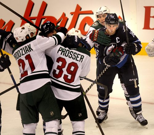 An angry Andrew Ladd is held back by Minnesota Wild's Jonathon Blum as team mate #127 James Wright is roughed up by a pack in the third period  Thursday. Winnipeg Jets See story. September 19, 2013 - (Phil Hossack / WInnipeg Free Press)