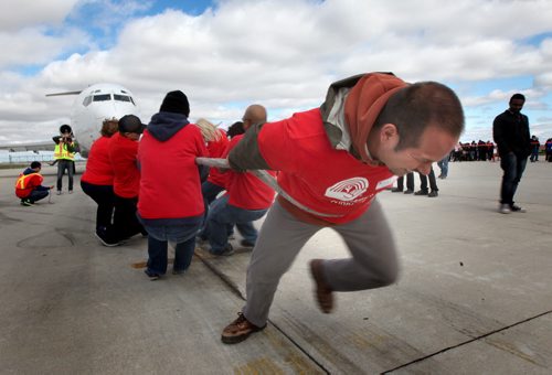 Shon Haynes strains into his harness leading the United Way team towing a large jetliner across the tarmac for the Annual United Way Kickoff. See Geoff Kirbyson's story. September 20, 2013 - (Phil Hossack / Winnipeg Free Press)