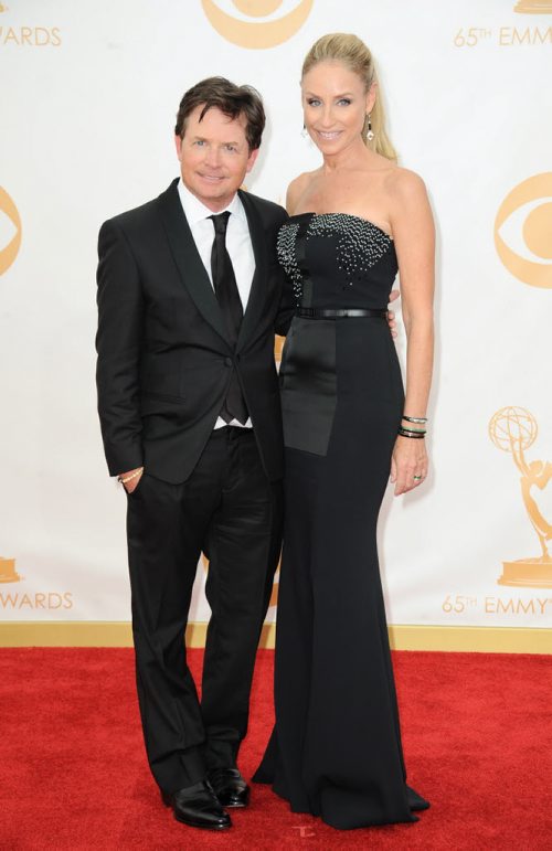 Michael J. Fox, left, and Tracy Pollan arrive at the 65th Primetime Emmy Awards at Nokia Theatre on Sunday Sept. 22, 2013, in Los Angeles.  (Photo by Jordan Strauss/Invision/AP)