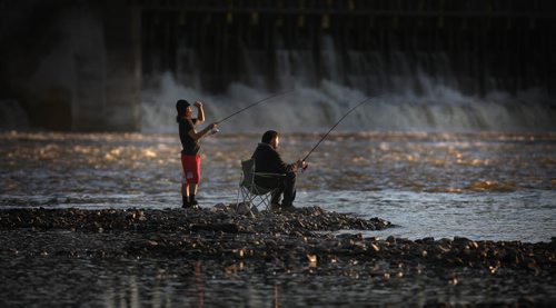 Fall Fishers, Charlie McConaghy (left) and Kevin Podolchuk bask in the evening glow at the foot of the Red River Control Structure and Locks in Lockport Tuesday evening. Warm weather and Goldeye brought out fall fishers in droves (and shorts).  September 24, 2013 - (Phil Hossack / Winnipeg Free Press)