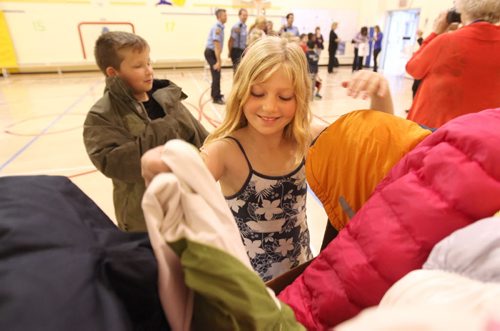 Eight year old Sara Stimpson and Ryker Gibson - 7yrs  grade 3 students from Assiniboine School dig through the 1st supply of coats as they help kick off the annual Coats for Kids fundraising campaign this year. Standup photo Sept  25,, 2013 Ruth Bonneville Winnipeg Free Press