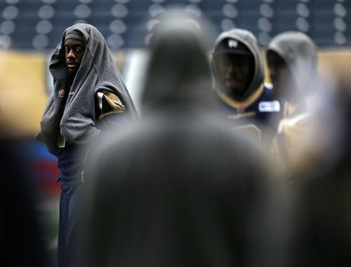 Practicing in the rain Äì Shelter from the Rain - SB #1 Kito Poblah  keeps dry   during walk through practice -  Wpg Blue Bombers prepare for BC Lions Friday night at Investors Stadium  KEN GIGLIOTTI / SEPT 26 2013 / WINNIPEG FREE PRESS