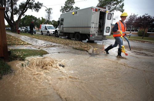 Water gushes out of the ground at the site of a water main break South of Portage ave at Ferry Road Thursday afternoon. See Aldo Santin story. September 26, 2013 - (Phil Hossack / Winnipeg Free Press)