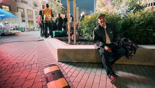 There but for the grace of.....Farron Hall sits in the shelter of shrubbery at Portage and Main listening to speeches Thursday evening at Portage and Main where local executives are camped out for the CEO Sleepout 2013.  Farron was asked to speak at the event, but turned down the offer. When I asked he didn't know where he was spending the night. See story?  September 26, 2013 - (Phil Hossack / Winnipeg Free Press)