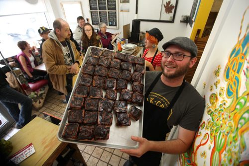 Jon McPhail, co-owner of Jonnies Stick Buns pulls out the remaining buns left on his shelves after having a Carrotmob, mobs of people coming out to celebrate businesses that go fair trade Saturday afternoon.  The sticky bun store is usually busy on Saturday's but today there was little room to move in the store with the mob of people. See story for more details.  Sept  28,, 2013 Ruth Bonneville Winnipeg Free Press