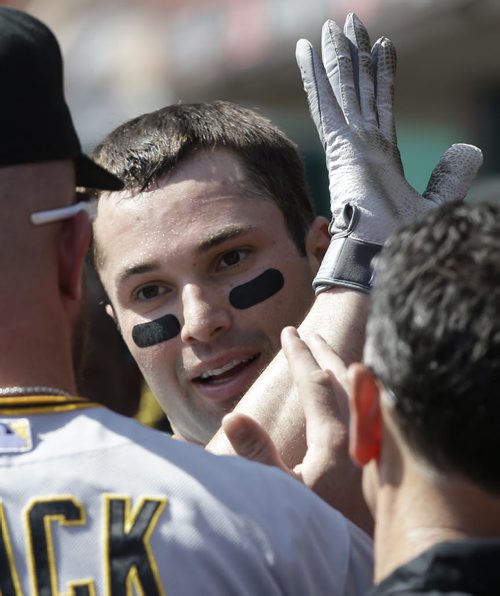 Pittsburgh Pirates' Neil Walker is congratulated in the dugout after hitting a solo home run off Cincinnati Reds starting pitcher Bronson Arroyo in the third inning of a baseball game, Saturday, Sept. 28, 2013, in Cincinnati. (AP Photo/Al Behrman)