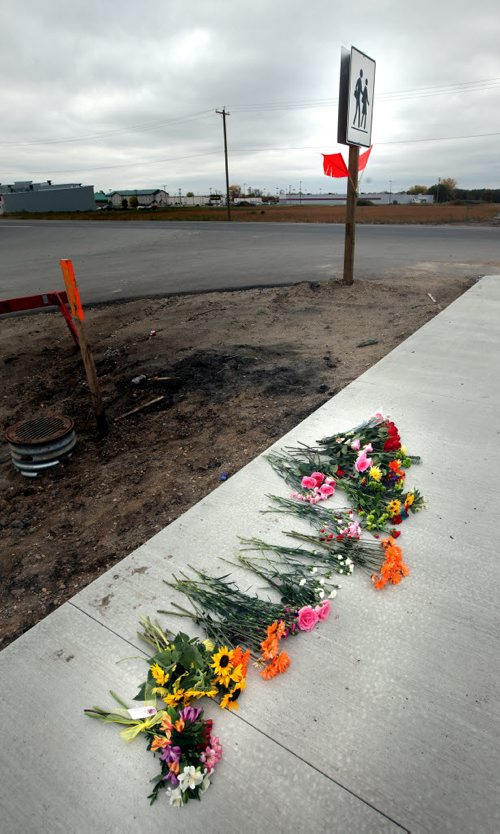 Flowers sit on a sidewalk beside Winkler's Northlands Parkway Collegiate Friday morning. A grade eleven student was struck and killled at the site Thursday. See story. October 4, 2013 - (Phil Hossack / Winnipeg Free Press)