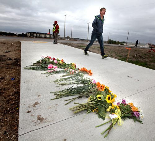 Students walk past a sidewalk memorial near Winkler's Northlands Parkway Collegiate Friday morning. A grade eleven student was struck and killled at the site Thursday. See story. October 4, 2013 - (Phil Hossack / Winnipeg Free Press)