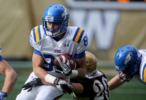 UBC Thunderbirds' Alex Morrison runs through a tackle by University of Manitoba Bisons' Mitchell Harrison during their game at Investors Group Field, Saturday, October 5, 2013. (TREVOR HAGAN/WINNIPEG FREE PRESS)