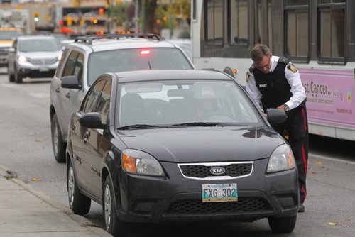 Insp. Jim Poole gives some cell phone tickets to drivers on Osborne. BORIS MINKEVICH / WINNIPEG FREE PRESS. Oct. 4, 2013