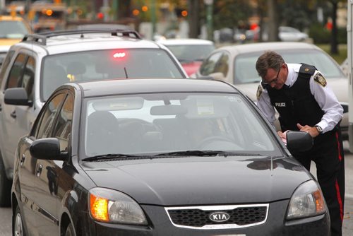 Insp. Jim Poole gives some cell phone tickets to drivers on Osborne. BORIS MINKEVICH / WINNIPEG FREE PRESS. Oct. 4, 2013