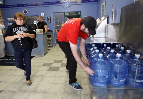 Anna Wiebe waits as World of Water employee Owen Swinn grabs her take home water from Dakota Ave store- The province of Manitoba ordered a boil water advisory for parts of South East Winnipeg after e coli was detected-See Ashley Prest story- Oct 09, 2013   (JOE BRYKSA / WINNIPEG FREE PRESS)