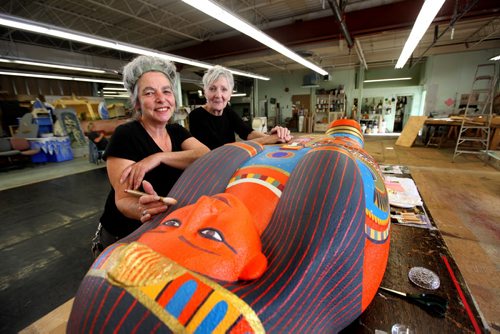Manitoba Museum's upcoming temporary exhibit called the Mummy of Pesed includes a giant sarcophagus designed and made by artist's Anne Armit (designer - long sleeved black shirt) and Kim Forrest (artist short sleeved shirt with hair up in front). See Ashley Prest story. Oct   08,, 2013 Ruth Bonneville Winnipeg Free Press
