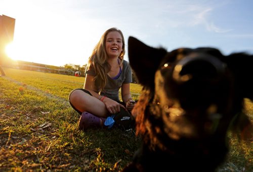 Hannah Hudson, 12, and her dog Molly watching the Vincent Massey Trojans play the Kelvin Clippers in High School Football at Vincent Massey Collegiate, Wednesday, October 9, 2013. (TREVOR HAGAN/WINNIPEG FREE PRESS)