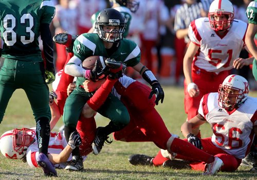 Vincent Massey Trojans' Matt Lemay is tackled by a gang of Kelvin Clippers during their High School Football game at Vincent Massey Collegiate, Wednesday, October 9, 2013. (TREVOR HAGAN/WINNIPEG FREE PRESS)