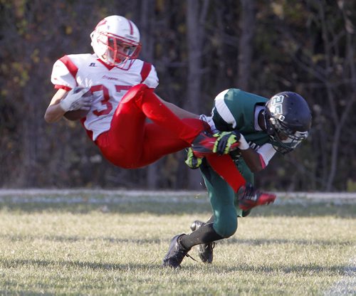 Kelvin Clippers' Jack Syverson is tackled by Vincent Massey Trojans' Abdul Gassama during their high school football game at Vincent Massey Collegiate, Wednesday, October 9, 2013. (TREVOR HAGAN/WINNIPEG FREE PRESS)
