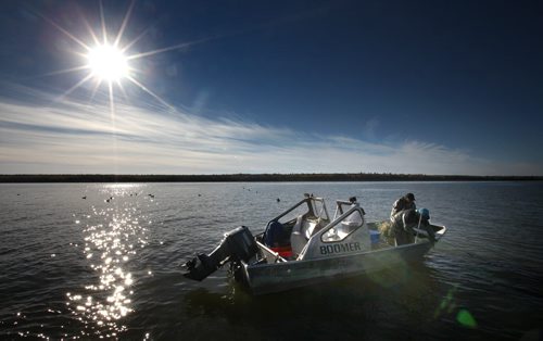 William Bird (blue cap) and his uncle Lloyd Bird begin checking nets in one of three boats Harvey Bushie's crew uses. Harvey Bushie and his son Rick harvest fish from the Lake Winnipeg Waters near Hollow Water. October 9, 2013 - (Phil Hossack / Winnipeg Free Press)