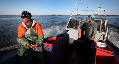 Taking in the Lake, enjoying a long days end, Rick Bushie sits forward in his fathers boat as the crew is ferried home. October 9, 2013 - (Phil Hossack / Winnipeg Free Press)