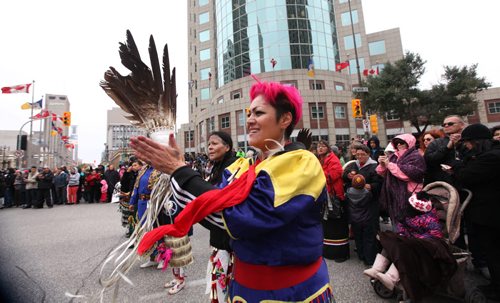 Jingle dancer Trish  Seymour dances with s large group of  drummers and jingle dancers gathered together at the corner of Portage and Main welcoming the UN Special Rapporteur on the Rights of Indigenous Peoples Saturday morning. The dance was followed by a march down to Thunderbird House.  Oct   12,, 2013 Ruth Bonneville Winnipeg Free Press