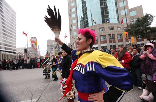 Jingle dancer Trish Seymour dances with s large group of  drummers and jingle dancers gathered together at the corner of Portage and Main welcoming the UN Special Rapporteur on the Rights of Indigenous Peoples Saturday morning. The dance was followed by a march down to Thunderbird House.  Oct   12,, 2013 Ruth Bonneville Winnipeg Free Press