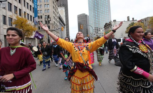 Jingle dress dancer Micheline Berard dances while marching down Main street toward Thunderbird House with a large group of jingle dancers and drummers that headed up a march welcoming the UN Special Rapporteur on the Rights of Indigenous Peoples Saturday morning.  Oct   12,, 2013 Ruth Bonneville Winnipeg Free Press