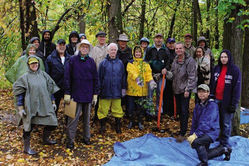 Canstar Community News Ron Mazur (with clipboard) and his group of local volunteers were all smiles Saturday morning despite the heavy rain, as they prepared to remove invasive European buckthorn shrubs from Crescent Drive Park.