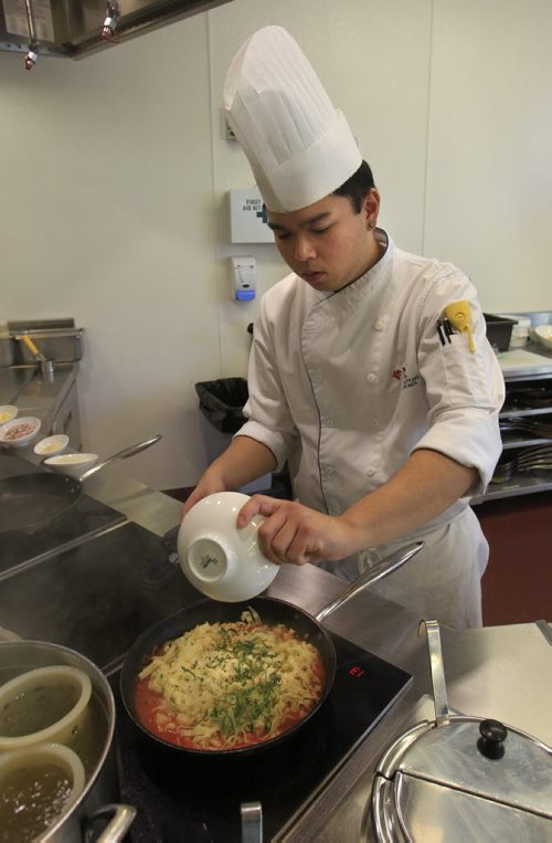 49.8 - rrc food column. Alex Wong prepares Chicken Parmigiana in the kitchen of the RRC School of Hospitality and Culinary Arts. Adds spices to pasta.  Keith F. Müller story Wayne Glowacki / Winnipeg Free Press Oct. 16 2013