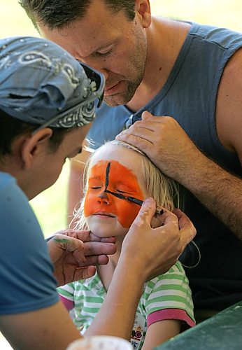 BORIS MINKEVICH / WINNIPEG FREE PRESS  070527 The 21st Annual Teddy Bears' Picnic at Assiniboine Park. Isabelle Carlson,3, gets her face painted. Her uncle Trent Whidden holds her hair as an unnamed face painting volunteer does his work.