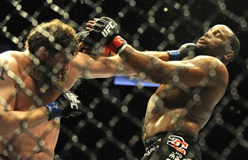 Roy Nelson, left, lands a puch against Daniel Cormier in a UFC heavyweight bout in Houston, Saturday, Oct. 19, 2013. Cormier won in a unanimous decision. (AP Photo/Pat Sullivan)