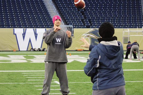 Canstar Community News Quarterback Justin Goltz works on a passing drill with one of the participants in the 2013 Women's Football Clinic. (JORDAN THOMPSON