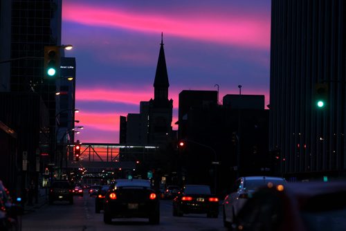Streaks of  vibrant Pink wrap the city skyline as seen driving west down St Mary Ave. Saturday evening. Standup photo  Ruth Bonneville / Winnipeg Free Press