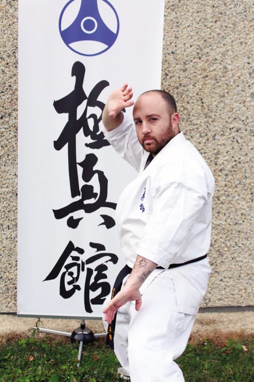 Canstar Community News Sean Devlin with the Kyokushin banner. (JORDAN THOMPSON)