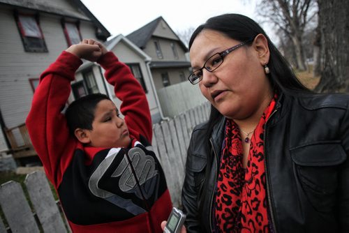 Elrond Starr, 10, stretches while his mom, Maria, talks about living in the North End and having "Party Houses" on her street. The provence has proposed changes to liquor legislation that would give police the ability to shut down party houses.  131031 October 31, 2013 Mike Deal / Winnipeg Free Press