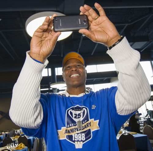 131101 Winnipeg - DAVID LIPNOWSKI / WINNIPEG FREE PRESS (November 01, 2013)  Retired Blue Bomber James West takes a photograph of the 1988 team plaque during a reunion of the 1988 Grey Cup championship Winnipeg Blue Bombers team, at the Pinnacle Club at Investors Group Field Friday afternoon.