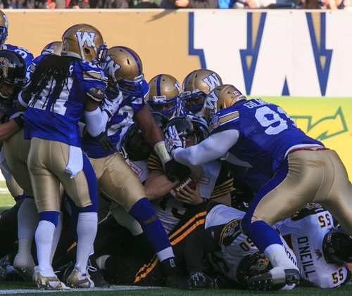 Ti-Cats back up QB Dan LeFevour passes over the end-zone in a mass of Blue Bombers. A penalty was called on the Ti-Cats, but they scored on the next play. Winnipeg Blue Bombers final game of the season against the Hamilton Tiger Cats at Investors Group Field on Saturday. 131023 - Wednesday, October 23, 2013 - (Melissa Tait / Winnipeg Free Press)
