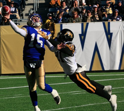 Bombers' QB Max Hall just gets rid of the ball just before Ti-Cats' DE Brandon Boudreaux takes him down in the first quarter. Winnipeg Blue Bombers final game of the season against the Hamilton Tiger Cats at Investors Group Field on Saturday. 131023 - Wednesday, October 23, 2013 - (Melissa Tait / Winnipeg Free Press)