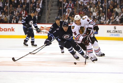Winnipeg Jet #17 James Wright tries to chase the puck away from Blackhawks #65 Andrew Shaw  during 2nd  period of play  Saturday afternoon at MTS Centre. November 02,,   Winnipeg Jets vs Chicago Blackhawks at MTS Centre Saturday. 2013 Ruth Bonneville / Winnipeg Free Press