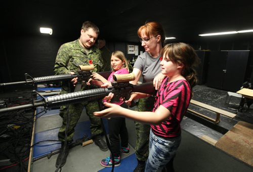 Megan Sawka (front) and her friend Darby  Riguidel learn how to shoot with a air gun with the help of Captain Riguidel and other army staff at Minto Armoury Saturday during their open house.  See Alex Paul story.  November 02,,  2013 Ruth Bonneville / Winnipeg Free Press